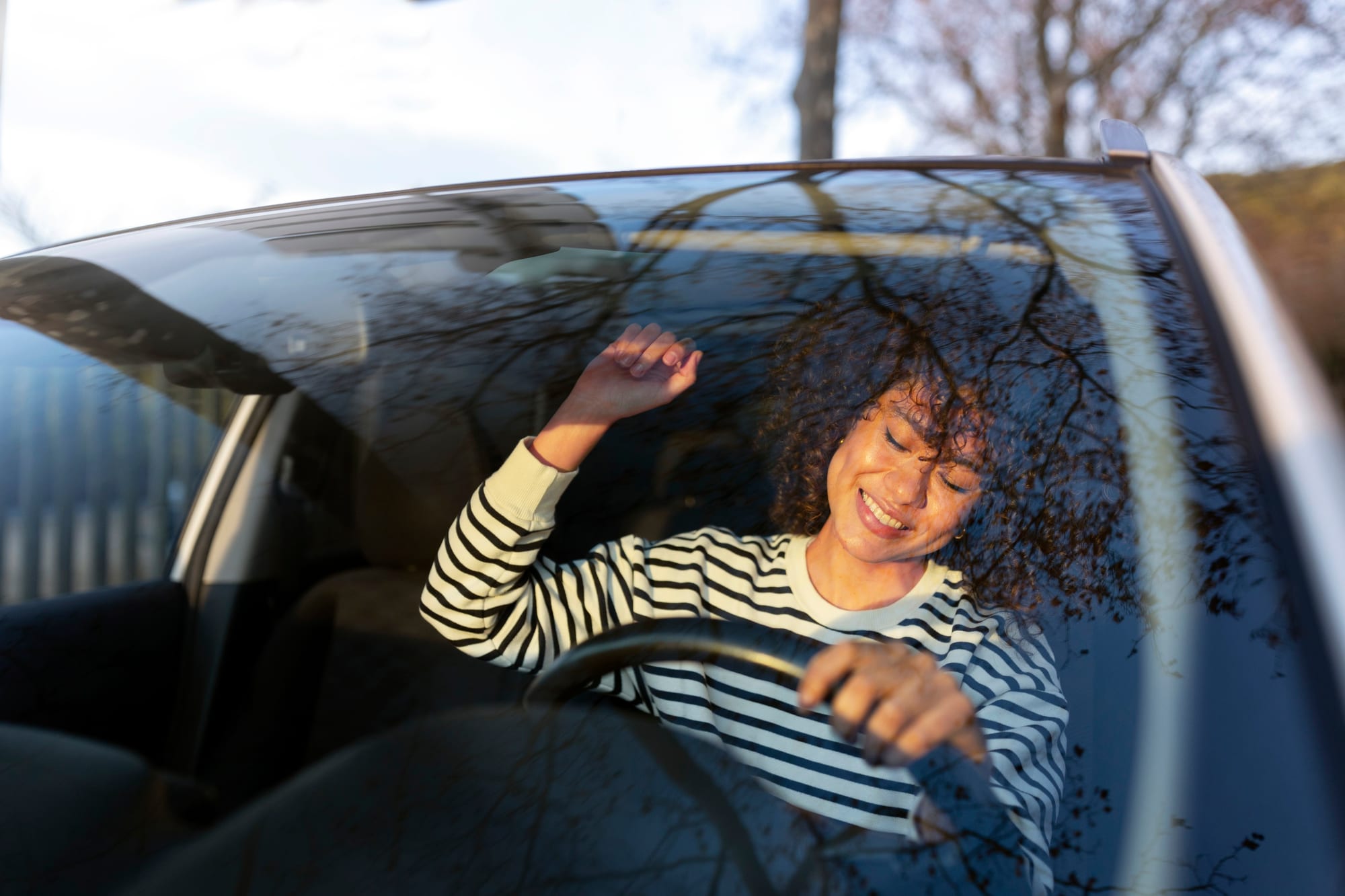 Élève souriante à la fenêtre d’une voiture